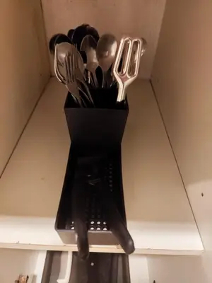 a black container filled with utensils on a shelf at Angelica Staycation at Mall of Asia Shell Residence in Manila