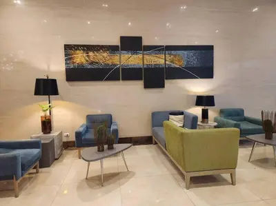 a lobby with a couch and chairs and a painting at Studio at viceroy 4 Taguig in Manila