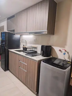 a kitchen with a stove and a sink and a refrigerator at Pet & WFH Friendly Home Near BGC in Manila