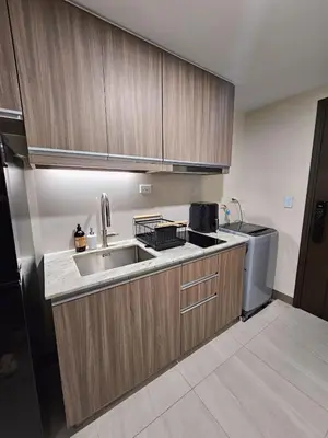 a kitchen with wooden cabinets and a sink and a refrigerator at Pet & WFH Friendly Home Near BGC in Manila