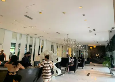 a group of people standing around a bar in a restaurant at Budget Suite Paranaque in Manila