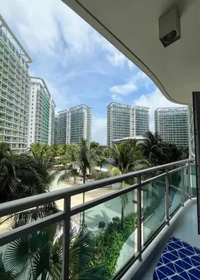 a balcony with a view of palm trees and buildings at Budget Suite Paranaque in Manila