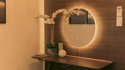 a bathroom with a mirror and flowers on a counter at The Skyline Oasis Makati in Manila