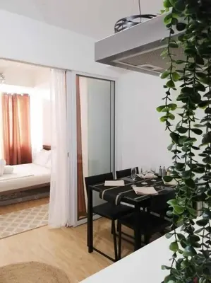 a dining room with a black table and a couch at Azure - Stellar Property in Manila