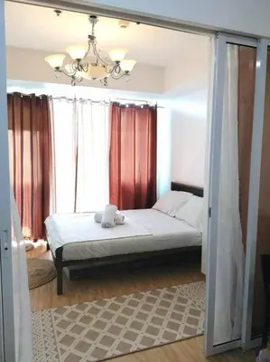 a bedroom with a bed in front of a window at Azure - Stellar Property in Manila
