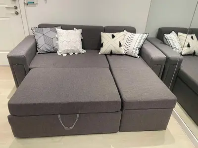 a gray couch with pillows on it in a room at High-end 2BR Condo Boracay Tower - Azure Residences near Manila Airport in Manila