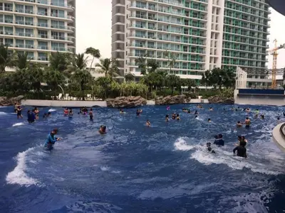 a group of people in a wave pool at a resort at High-end 2BR Condo Boracay Tower - Azure Residences near Manila Airport in Manila