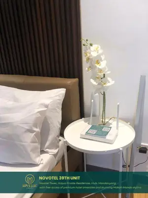 a vase of flowers on a table next to a bed at Novotel Twin Bed at Mandaluyong Near Makati FREE pool in Manila
