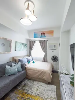 a living room with a bed and a couch at University Belt Cozy Studio at Vista Recto-33rd Floor in Manila