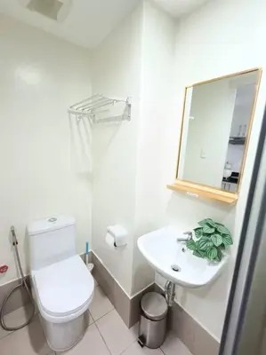 a white bathroom with a toilet and a sink at University Belt Cozy Studio at Vista Recto-33rd Floor in Manila