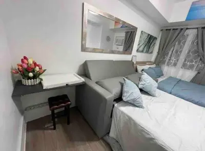 a small room with a couch and a table at University Belt Cozy Studio at Vista Recto-33rd Floor in Manila