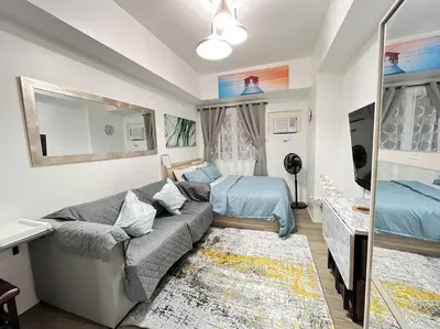 a living room with a couch and a bed at University Belt Cozy Studio at Vista Recto-33rd Floor in Manila