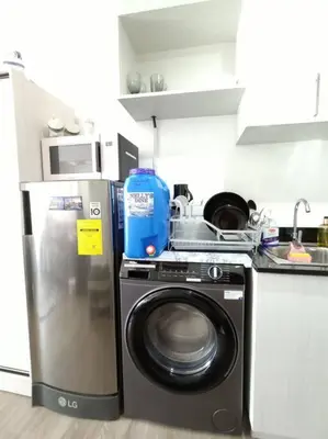 a kitchen with a washing machine and a refrigerator at University Belt Cozy Studio at Vista Recto-33rd Floor in Manila
