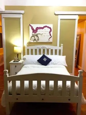 a bedroom with a white bed with a white headboard at Greenhills 1BR Lower Penthouse w Panoramic View in Manila