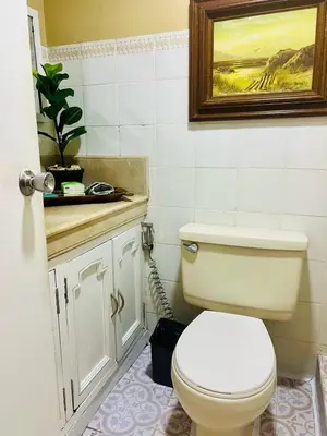 a bathroom with a toilet and a painting on the wall at Greenhills 1BR Lower Penthouse w Panoramic View in Manila