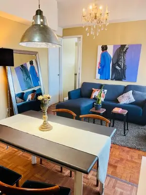 a living room with a blue couch and a table at Greenhills 1BR Lower Penthouse w Panoramic View in Manila