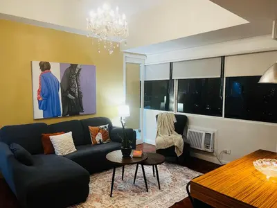 a living room with a couch and a table at Greenhills 1BR Lower Penthouse w Panoramic View in Manila