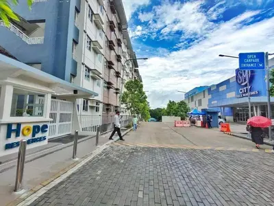 a man walking down a street next to buildings at Zenrise Staycation in Trece Martires
