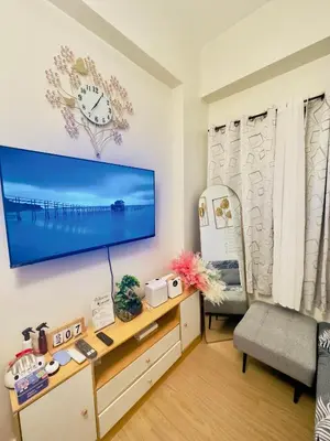 a living room with a large flat screen tv on a wall at Zenrise Staycation in Trece Martires