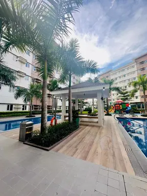 a pavilion with palm trees in front of a building at Zenrise Staycation in Trece Martires