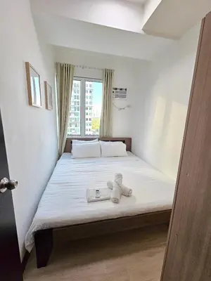 a bedroom with a bed with a teddy bear on it at Spacious 2BR Condo San Lorenzo Place 4KM Airport in Manila