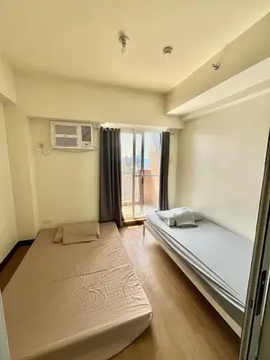 a bedroom with two beds and a window at West Bricks in Manila