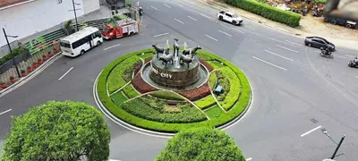 a street with a statue in the middle of a road at Avah cozy condotel 150 Newport boulavevard Pasay city in Manila