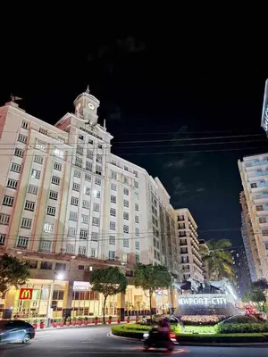a large building with a clock tower on top of it at Avah cozy condotel 150 Newport boulavevard Pasay city in Manila
