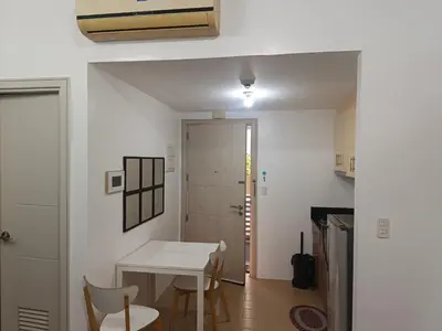 a small kitchen with a table and chairs in a room at Avah cozy condotel 150 Newport boulavevard Pasay city in Manila
