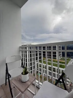a balcony with a chair and a table and a building at Shore Residence Manila Bay City Lights View MOA Complex in Manila