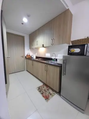 a kitchen with wooden cabinets and a stainless steel refrigerator at Shore Residence Manila Bay City Lights View MOA Complex in Manila