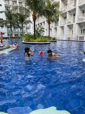 a group of people in the swimming pool at a hotel at Shore Residence Manila Bay City Lights View MOA Complex in Manila
