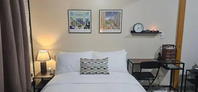 a bedroom with a bed with four pictures on the wall at City Life Suite Uptown BGC in Manila