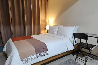 a bedroom with a bed and a desk and a chair at City Life Suite Uptown BGC in Manila