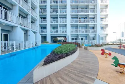 a swimming pool in front of a large building at SMDC Breeze Residences by RedDoorz in Manila