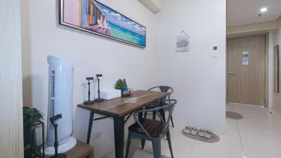 a dining room with a wooden table and chairs at SMDC Breeze Residences by RedDoorz in Manila