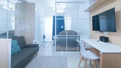 a small living room with a couch and a tv at SMDC Breeze Residences by RedDoorz in Manila