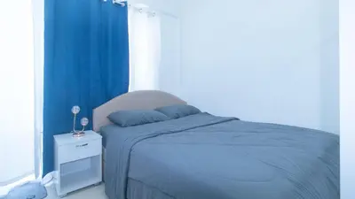 a bedroom with a blue bed and a window at SMDC Breeze Residences by RedDoorz in Manila