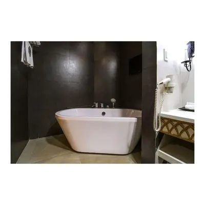 a white tub in a bathroom with a sink at Summit Hotel Magnolia in Manila