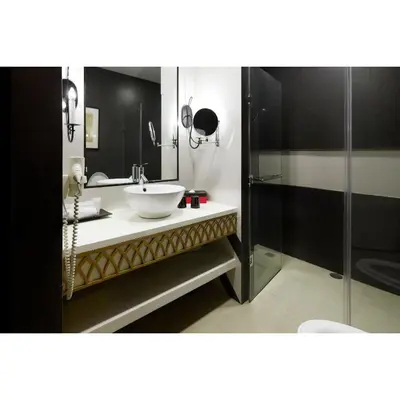 a bathroom with a sink and a glass shower at Summit Hotel Magnolia in Manila