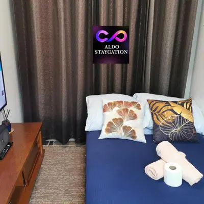 a bed with two pillows and a sign on it at Mall of Asia Pasay Shore 3 tower 2 Residences in Manila