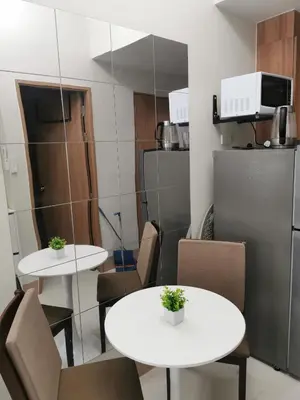 two tables and chairs in a room with a refrigerator at Mall of Asia Pasay Shore 3 tower 2 Residences in Manila