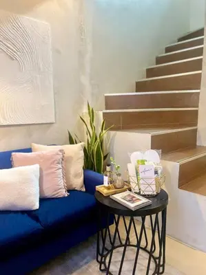 a blue couch with a table next to a staircase at Modern minimalist house in the heart of Antipolo in Antipolo