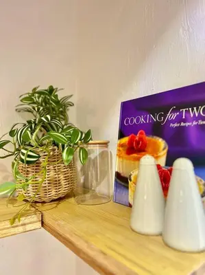 a shelf with a plant and a book and a cake at Tropical hideaway near Antipolo Cathedral in Antipolo