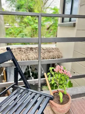 a potted plant sitting next to a bench on a balcony at Tropical hideaway near Antipolo Cathedral in Antipolo