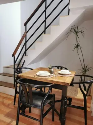 a dining room table with chairs and a staircase at Tropical hideaway near Antipolo Cathedral in Antipolo