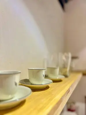 three coffee cups and saucers on a wooden shelf at Tropical hideaway near Antipolo Cathedral in Antipolo