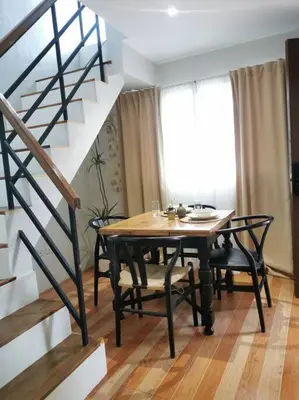 a dining room with a table and chairs and a staircase at Tropical hideaway near Antipolo Cathedral in Antipolo