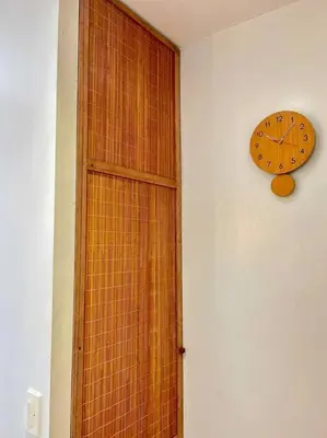 a clock on a wall next to a wooden door at Tropical hideaway near Antipolo Cathedral in Antipolo