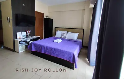a bedroom with a purple bed and a tv at Condotel Near Naia Terminal 3 in Manila